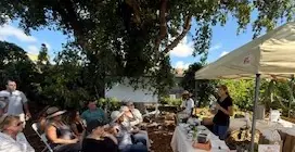 A MetM community garden workshop gathering under the trees in South Florida